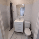 Petite salle de bain avec douche, lavabo et WC